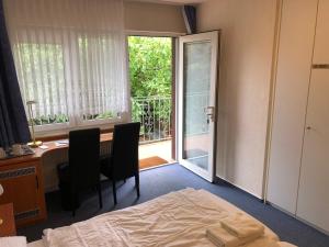 Schlafzimmer mit einem Bett, einem Schreibtisch und einem Fenster in der Unterkunft Gästehaus Am Vogelsang in Kerpen