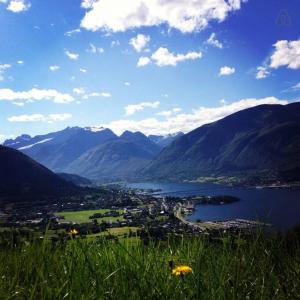 a view of a city and a lake with mountains at Minihus med drømmeutsikt til Sunnmørsalpene in Aure