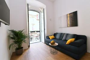 een woonkamer met een blauwe bank en een tafel bij Vitopolis 1&2 in Rijeka
