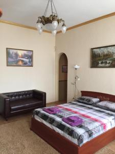 a bedroom with a bed and a couch at Затишна квартира в центрі міста in Ternopilʼ