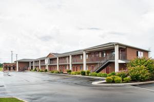 a row of apartment buildings in a parking lot at Luxbury Inn & Suites in West Maryville