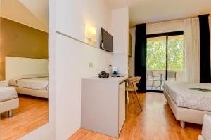 a hotel room with two beds and a desk in it at Hotel Riel in Sirmione