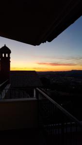 een uitzicht op de zonsondergang vanuit een gebouw met een klokkentoren bij B&B Villa Sole in Controguerra