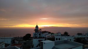 a sunset over a city with a church at I MITI ViviendaVacacional in Chio