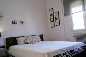 um quarto branco com uma cama e uma janela em Comfy central flat em Tessalônica