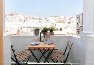 einen Tisch und Stühle auf einem Balkon mit Aussicht in der Unterkunft Boutike Wellness Centro Almería in Almería