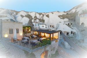 an aerial view of a house with snow covered mountains at Melek Cave Hotel in Goreme