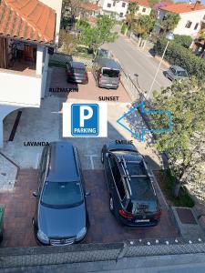 dois carros estacionados um ao lado do outro num parque de estacionamento em Villa Aleksandar Porec em Porec