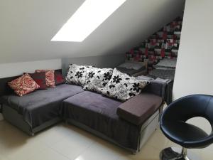 un sofá con almohadas y una silla en una habitación en Słoneczne Zacisze, en Wicko