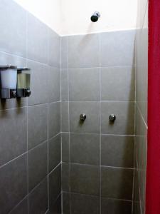 La salle de bains est pourvue d'une douche avec du carrelage gris. dans l'établissement Guaya Hostel, à Mérida