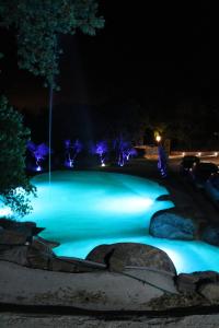 a pool lit up at night with blue lights at La Quercia in Arbus