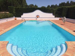 a large swimming pool with blue water on a wooden deck at Quarto em Monte Alentejano perto do Cercal in Cercal