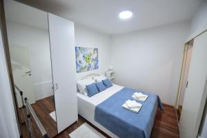 a bedroom with a bed with blue sheets and pillows at Gardos house above Danube in Belgrade