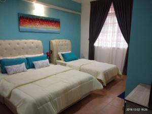 a bedroom with two beds and a window at aAdy Homestay in Ketereh