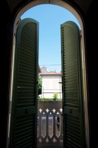 eine offene Tür zu einem Balkon mit einem Haus im Hintergrund in der Unterkunft Il Balconcino sulle Terme in San Giuliano Terme