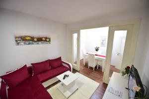 a living room with a red couch and a table at Gardos house above Danube in Belgrade