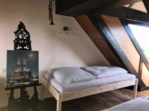 Cama en habitación con techo de madera en Fewo TURMZIMMER im Rittergut Leppersdorf bei Dresden, en Leppersdorf