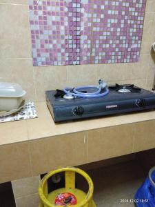 a kitchen counter with a stove on a counter top at aAdy Homestay in Ketereh