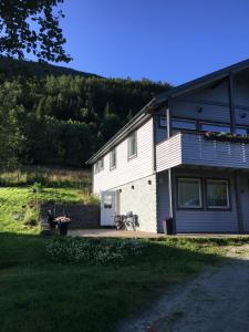 una casa blanca con un patio y una casa en Hundbergan apartment-free parking-15 min from Tromsø en Tromsdalen