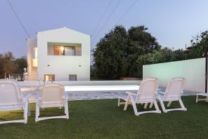a group of chairs sitting on the grass near a pool at Mediterraneo in San Teodoro