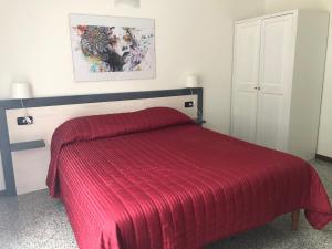 a bedroom with a red bed with a red blanket at La Casa di Anna in Delebio
