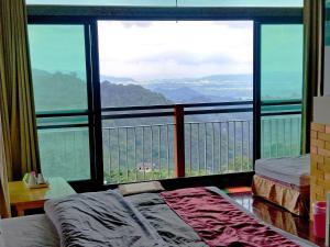 a bedroom with a large window with a view of the mountains at King Villa in Heping