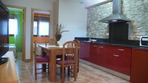 a kitchen with a wooden table with chairs and a stove at Mircla in Rocafort de Queralt