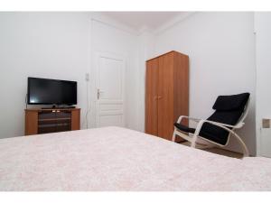 um quarto com uma cama, uma cadeira e uma televisão em Apartment in centre with huge terace em Pula