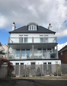 a large white house with a black roof at Lyme View Apartment in Lyme Regis