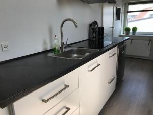 a kitchen with a sink and a black counter top at Vesterhavsvej in Hvide Sande