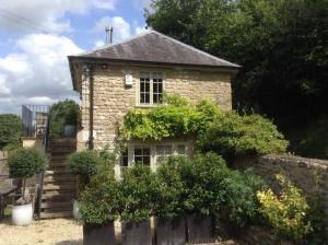 an old stone house with bushes in front of it at The Lodge in Bath