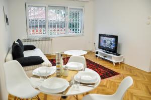 Zvekir - Old Town Apartment في سراييفو: غرفة معيشة بأثاث أبيض وتلفزيون