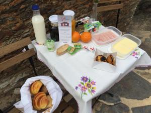 a table with bread and milk and food on it at Casa da Chapinheira in São Pedro de Alva