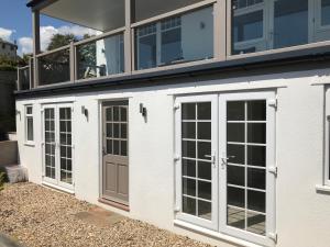 una fila de puertas en un edificio blanco en Lyme View Apartment en Lyme Regis