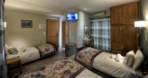 pokój hotelowy z dwoma łóżkami i telewizorem w obiekcie Tassos Rooms w mieście Kórinthos
