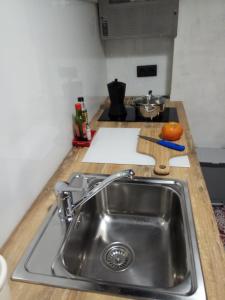 encimera de cocina con fregadero y tabla de cortar de naranja en Oskorri, loft centrico y moderno, en Getaria