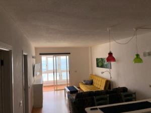 ein Wohnzimmer mit einem Sofa und einem Tisch in der Unterkunft Calle del Sol Bajamar Apartment in La Laguna