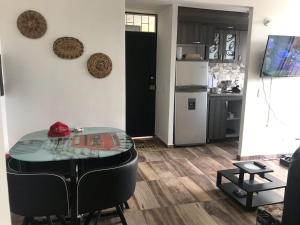a dining room with a table and a kitchen at Apartamento vacacional Ibagué in Ibagué +5 photos