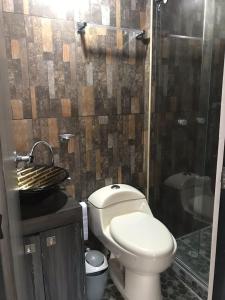 a bathroom with a toilet and a glass shower at Apartamento vacacional Ibagué in Ibagué