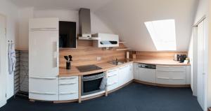 a kitchen with white cabinets and a wooden counter top at Ferienwohnung Michael in Aigen im Ennstal