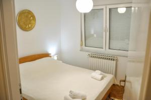 Zvekir - Old Town Apartment في سراييفو: غرفة نوم صغيرة عليها سرير وفوط