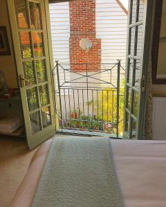 een slaapkamer met een deur naar een balkon met een poort bij The Tea House in Rye