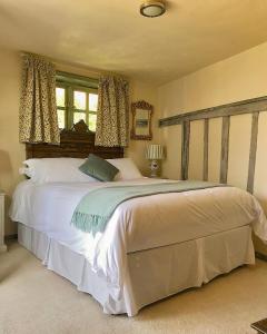 a bedroom with a large bed with white sheets at The Tea House in Rye