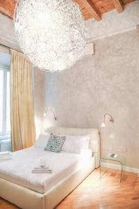 una camera da letto con un letto e un grande lampadario a braccio di Ilsanleonardo a Bergamo