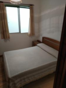 a bedroom with two beds and two windows at HOSTAL RESIDENCIA PRESIDENTE in Ribadeo