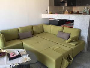 a green couch in a living room with a table at Apartment zone touristique 80 m beach free wifi in Mahdia