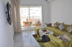 a living room with a couch and a table at Apartment zone touristique 80 m beach free wifi in Mahdia