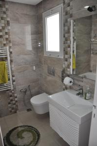a bathroom with a sink and a toilet and a window at Apartment zone touristique 80 m beach free wifi in Mahdia