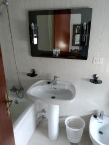 a bathroom with a sink and a mirror and a tub at HOSTAL RESIDENCIA PRESIDENTE in Ribadeo