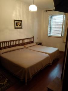 a bedroom with two beds and a window at HOSTAL RESIDENCIA PRESIDENTE in Ribadeo